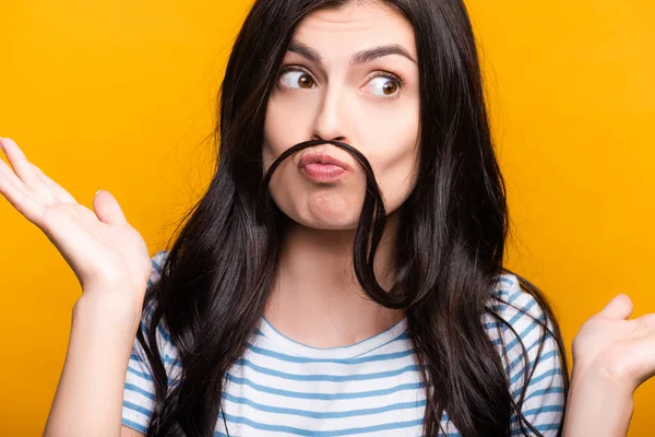 Mulher morena com cachos fazendo bigode falso de cabelo isolado no amarelo — Fotografia de Stock