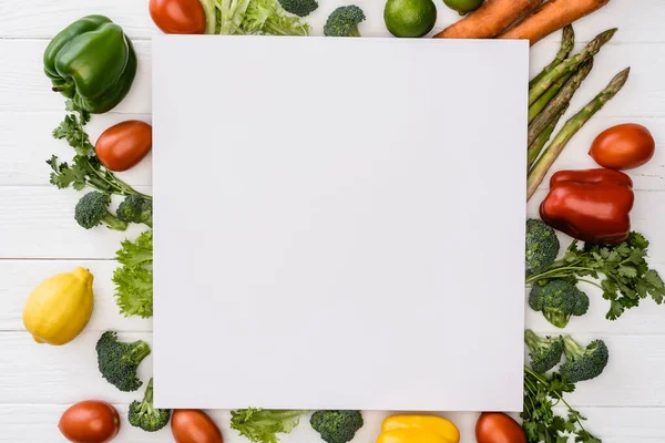 Draufsicht auf frisches reifes Gemüse und Obst in der Nähe von leeren quadratischen Plakat auf weißem Holzgrund — Stockfoto