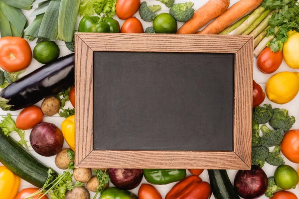 Blick von oben auf frisches reifes Gemüse und Obst in der Nähe leerer Tafeln — Stockfoto