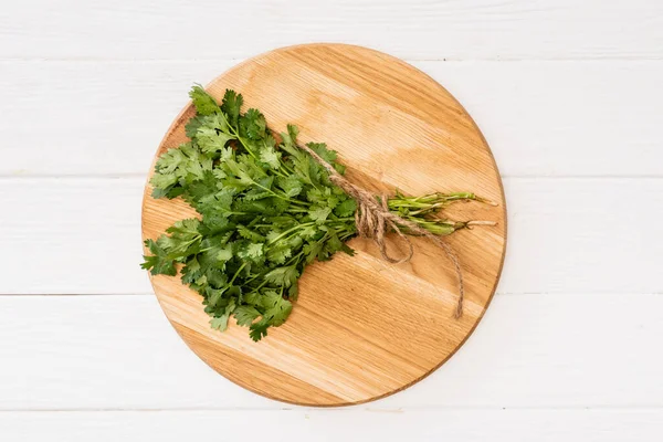 Vue du dessus du persil sur planche à découper sur table en bois blanc — Photo de stock