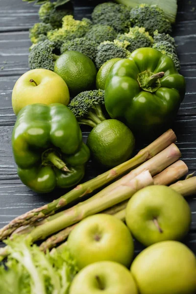 Foco seletivo de frutas e legumes verdes frescos maduros na superfície de madeira — Fotografia de Stock