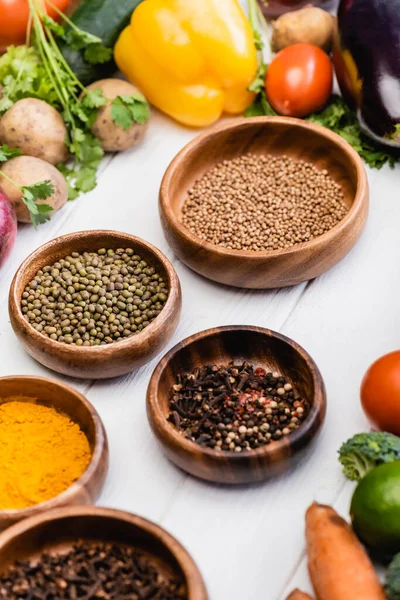 Legumes frescos maduros e frutas ao redor tigelas com especiarias em fundo branco de madeira — Fotografia de Stock