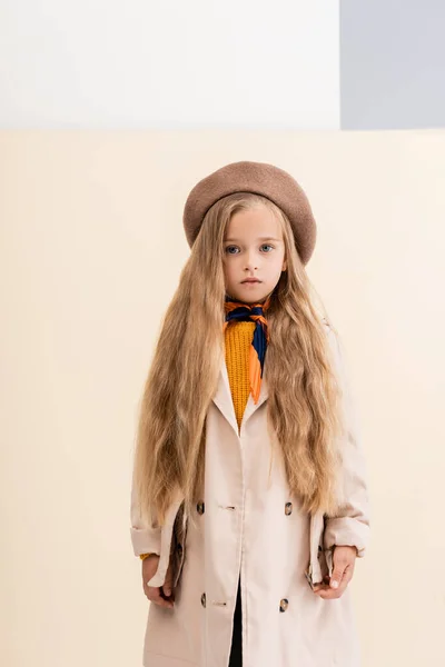 Fashionable blonde girl in autumn outfit on beige and white background — Stock Photo