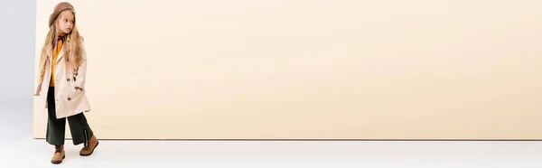 Модная блондинка в осеннем наряде прогулка на бежевом и белом фоне, панорамный снимок — стоковое фото