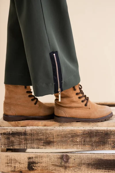 Vista cortada da menina na moda em botas andando na caixa de madeira — Fotografia de Stock
