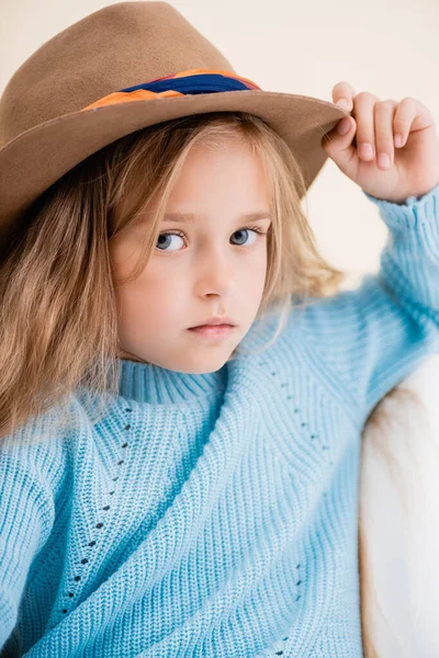 Fille blonde à la mode en chapeau brun et pull bleu — Photo de stock