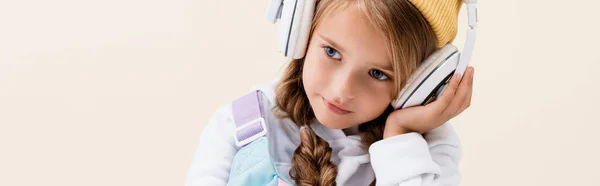 Blonde girl in sportswear and headphones isolated on beige, panoramic shot — Stock Photo