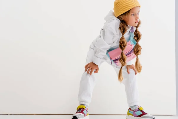 Ragazza bionda in abbigliamento sportivo posa vicino al muro bianco — Foto stock