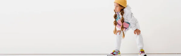 Blondes Mädchen in Sportbekleidung posiert in der Nähe der weißen Wand, Panoramaaufnahme — Stockfoto