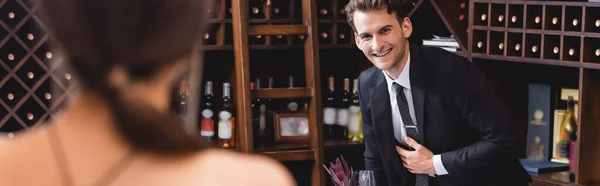 Panoramic shot of man in suit looking at girlfriend during dating in restaurant — Stock Photo