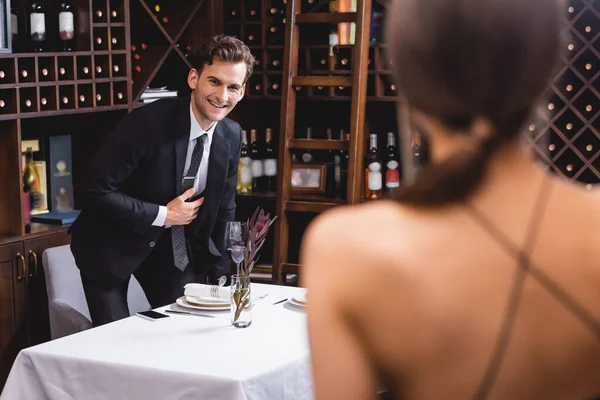 Enfoque selectivo del hombre en ropa formal mirando a la novia durante las citas en el restaurante - foto de stock