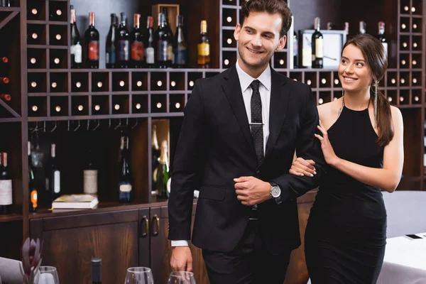 Selective focus of elegant woman touching hand of boyfriend in formal wear in restaurant — Stock Photo