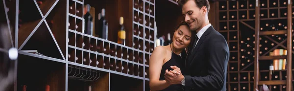Imagen horizontal de mujer elegante bailando con novio en traje durante citas en restaurante - foto de stock