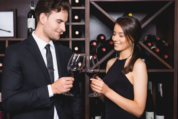 Elegante pareja tintineo con vino durante citas en el restaurante - foto de stock