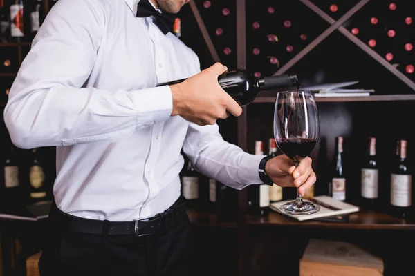 Обрізаний вид сомельє в офіційному одязі, що поливає вино в ресторані — стокове фото