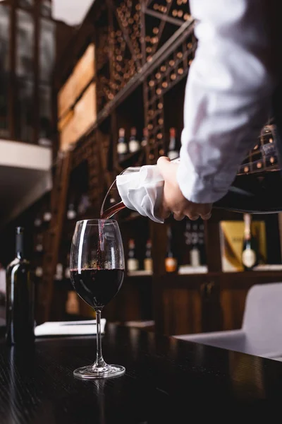 Foco seletivo de sommelier em camisa derramando vinho de decantador em vidro — Fotografia de Stock