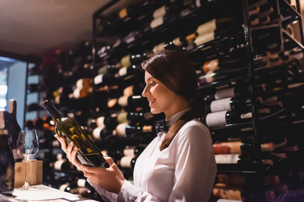 Enfoque selectivo del sommelier sosteniendo botella de vino en el restaurante - foto de stock