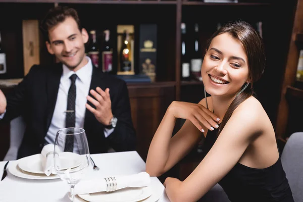 Selektiver Fokus der jungen Frau, die bei Dating in Restaurant in der Nähe ihres Freundes wegschaut — Stockfoto