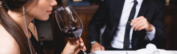 Cabeçalho do site de jovem mulher cheirando vinho em vidro perto do homem — Fotografia de Stock