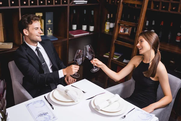 Избранное внимание элегантной пары тост с бокалами вина за столом в ресторане — стоковое фото