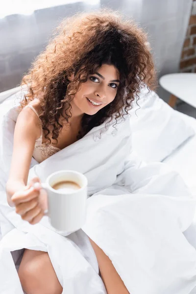 Foco seletivo da mulher alegre segurando xícara de café pela manhã — Fotografia de Stock