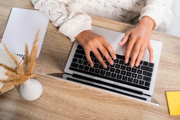 Top view of young woman typing on laptop at home — Stock Photo