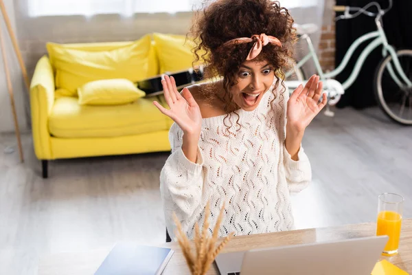 Selective focus of excited woman laughing and looking at laptop — Stock Photo