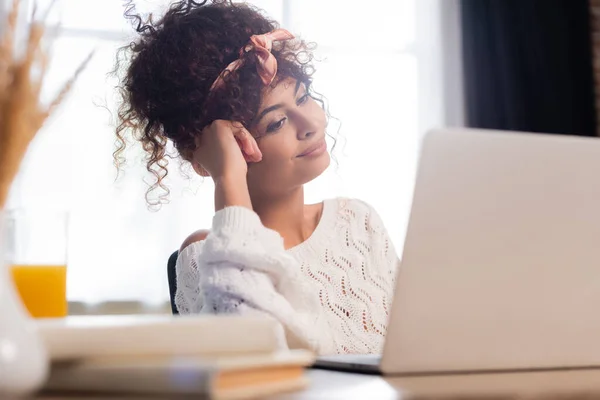 Selective focus of pleased woman looking at laptop — Stock Photo