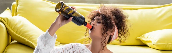 Plano panorámico de la mujer bebiendo vino de botella - foto de stock