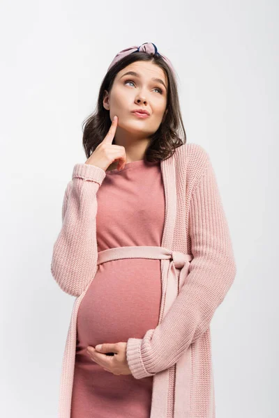 Усвідомлена вагітна жінка в пов'язці торкається обличчя і дивиться вгору ізольовано на білому — стокове фото