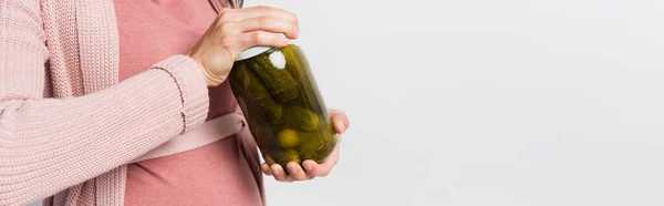 Horizontal crop of pregnant woman opening jar with sour and pickled cucumbers isolated on white — Stock Photo