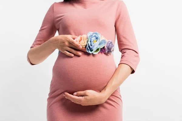 Abgeschnittene Ansicht einer schwangeren Frau mit floralem Gürtel, der den Bauch berührt, isoliert auf Weiß — Stockfoto