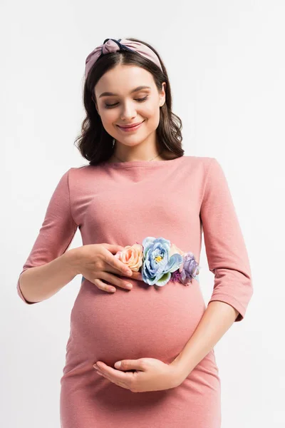 Joyeuse femme enceinte avec ceinture florale toucher ventre isolé sur blanc — Photo de stock