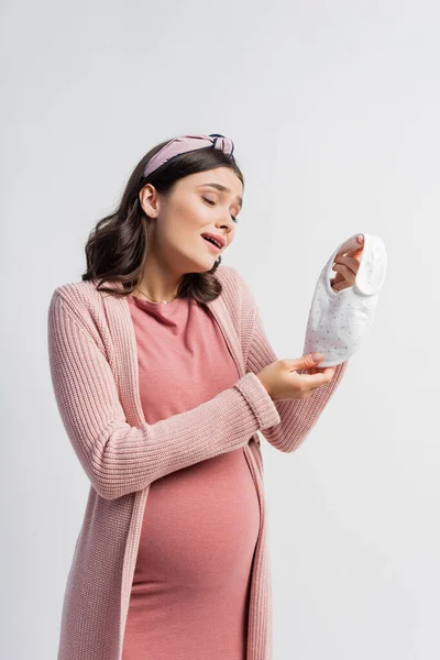 Mujer embarazada mirando pequeño bebé babero aislado en blanco - foto de stock