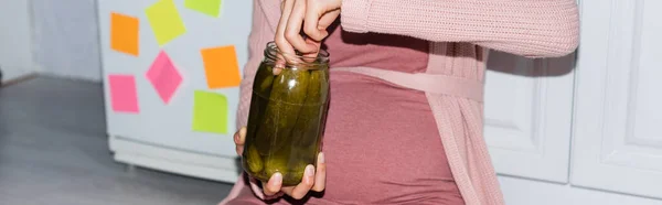 Website header of pregnant woman holding canned jar with cucumbers at home — Stock Photo