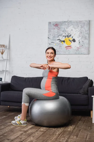 Schwangere trainiert mit Fitnessball im Wohnzimmer — Stockfoto