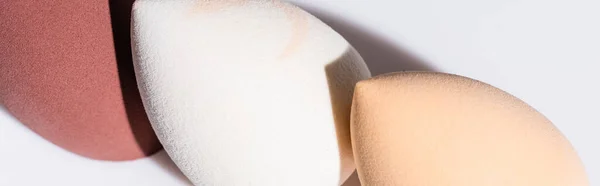 Close up view of makeup sponges on white background, panoramic shot — Stock Photo