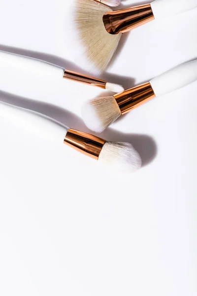 Vista dall'alto di pennelli cosmetici impostati su sfondo bianco — Foto stock