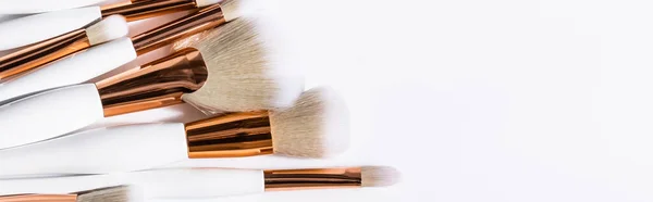 Top view of cosmetic brushes set on white background with copy space, panoramic shot — Stock Photo