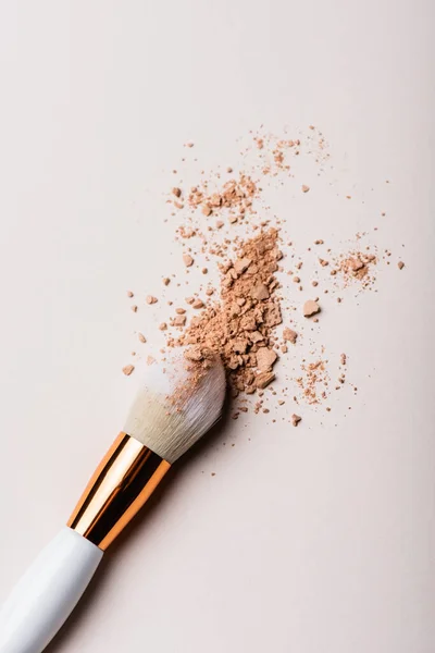 Top view of cosmetic brush with face powder on beige background — Stock Photo