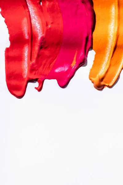 Vista superior de vermelho, laranja e rosa pinceladas abstratas no fundo branco — Fotografia de Stock