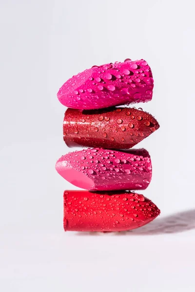Close up view of wet colorful lipsticks on white background — Stock Photo
