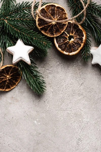 Vista superior de fatias de laranja seca, biscoitos e galho de pinho no fundo texturizado — Fotografia de Stock