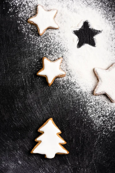 Vista superior de galletas de jengibre de Navidad cubiertas con azúcar en polvo - foto de stock