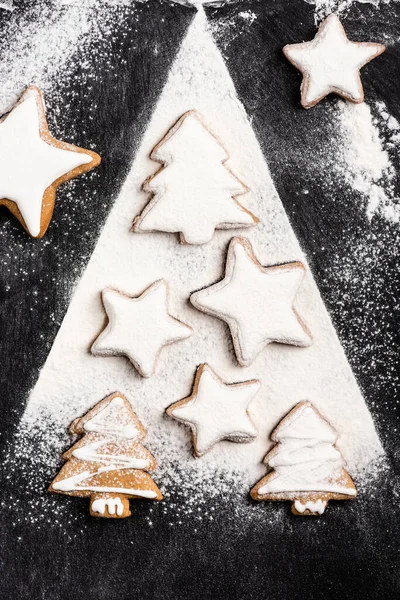 Vista superior de galletas de jengibre de Navidad cubiertas con azúcar en polvo - foto de stock