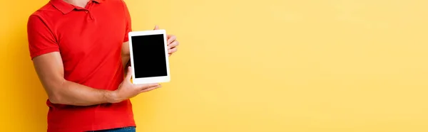 Cropped view of man holding digital tablet with blank screen on yellow, banner — Stock Photo