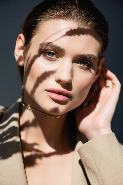 Ombres de blé sur le visage de la jeune femme sur fond gris foncé — Photo de stock