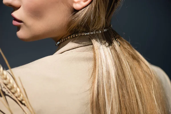 Ausgeschnittene Ansicht einer Frau in beigem Blazer und Halskette bei Weizen auf dunkelgrau — Stockfoto