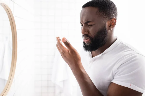Hombre afroamericano respirando mal olor de boca - foto de stock