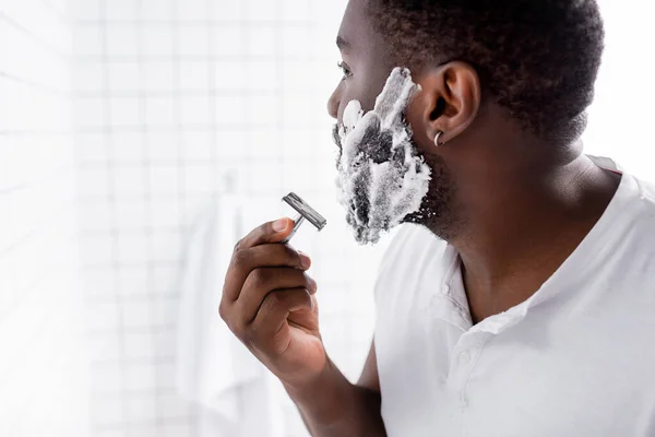 Afro-américain homme rasage barbe avec rasoir — Photo de stock